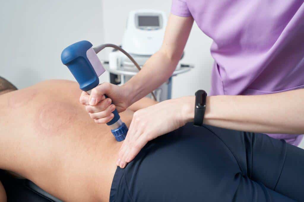 Man receiving shockwave therapy treatment in rehabilitation clinic
